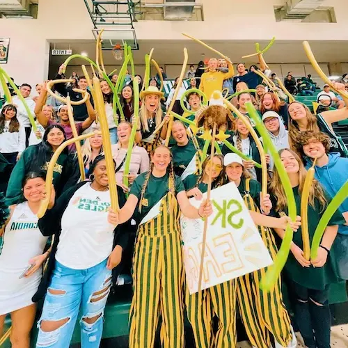 Students posing for a photo at a basketball game